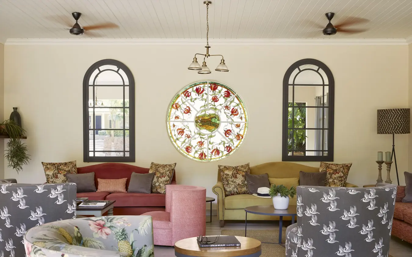 Elegant lounge with arched windows and decorative plate clock, Batonka Guest Lodge, Victoria Falls, Zimbabwe