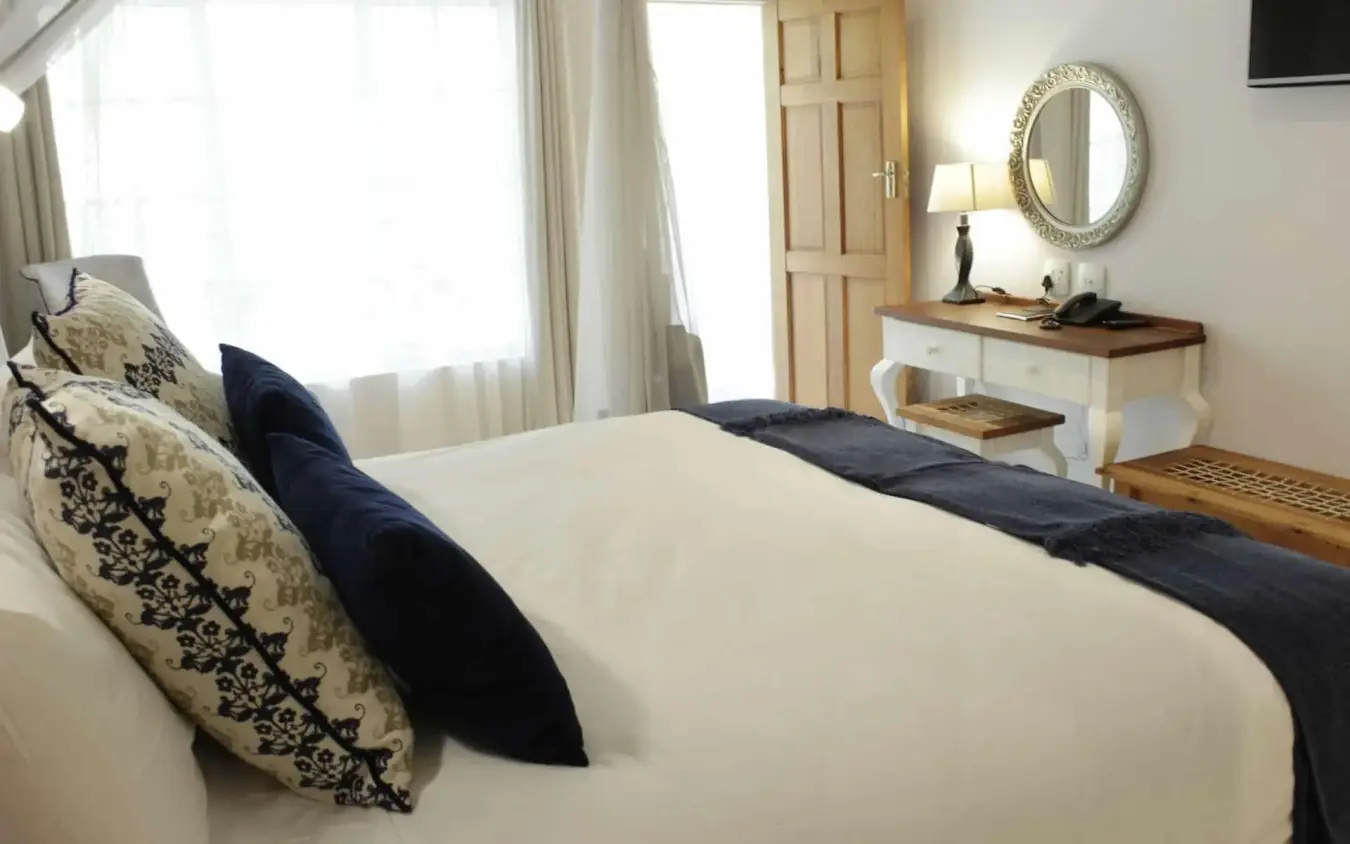 Bedroom with white linens, decorative pillows, and natural light, Batonka Guest Lodge, Victoria Falls, Zimbabwe