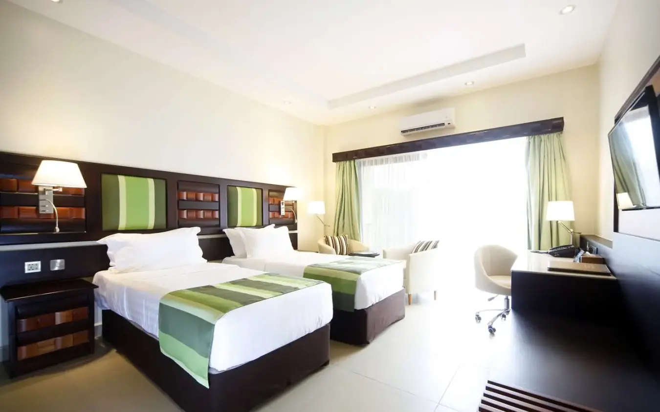 Twin beds with green accents and dark wood furniture, Best Western Premier Garden Hotel Entebbe, Entebbe and Kampala, Uganda