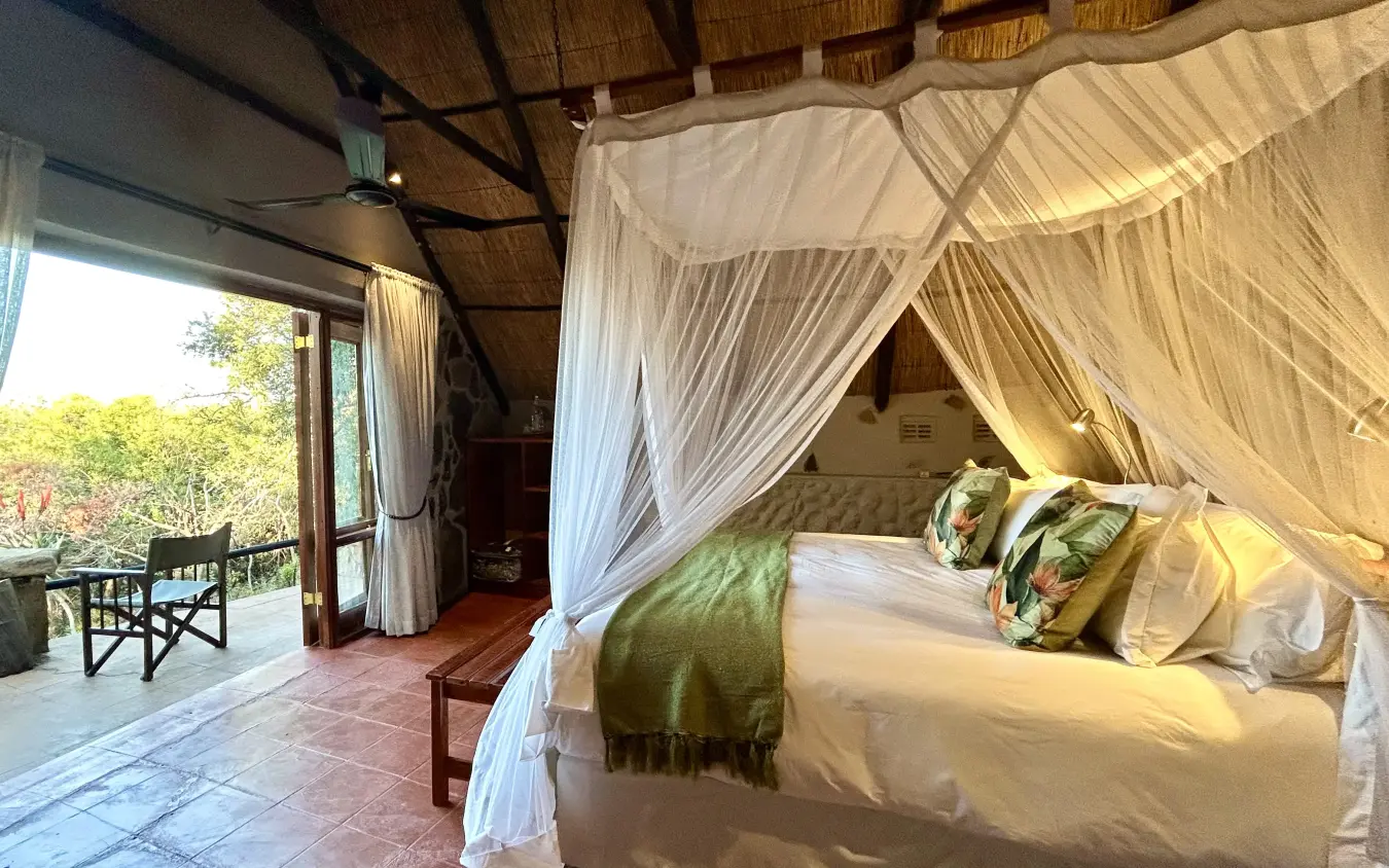 Canopy bed suite with open deck overlooking woodland vegetation, Big Cave Camp, Matobo, Zimbabwe