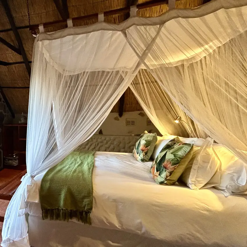 Canopy bed suite with open deck overlooking woodland vegetation, Big Cave Camp, Matobo, Zimbabwe