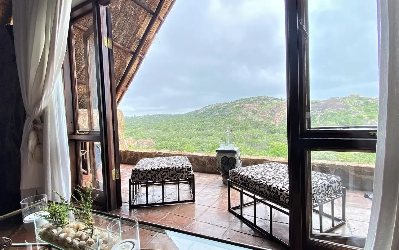Bedroom with twin beds overlooking green hills and savanna landscape, Big Cave Camp, Matobo, Zimbabwe