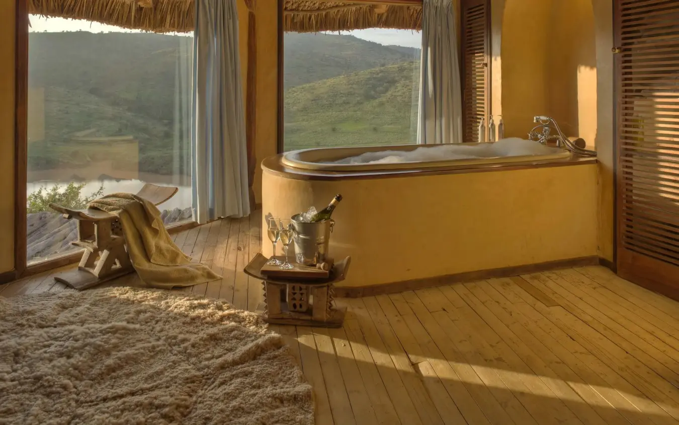 Luxury bathroom with soaking tub overlooking green valley landscape, Borana Lodge, Laikipia Highlands, Kenya