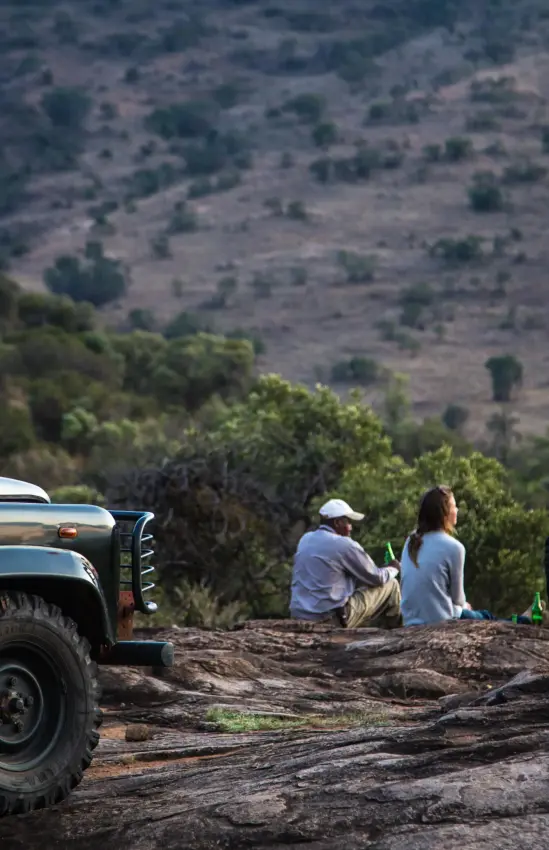 Safari vehicle with guests observing vast hillside landscape, Borana Lodge, Laikipia Highlands, Kenya