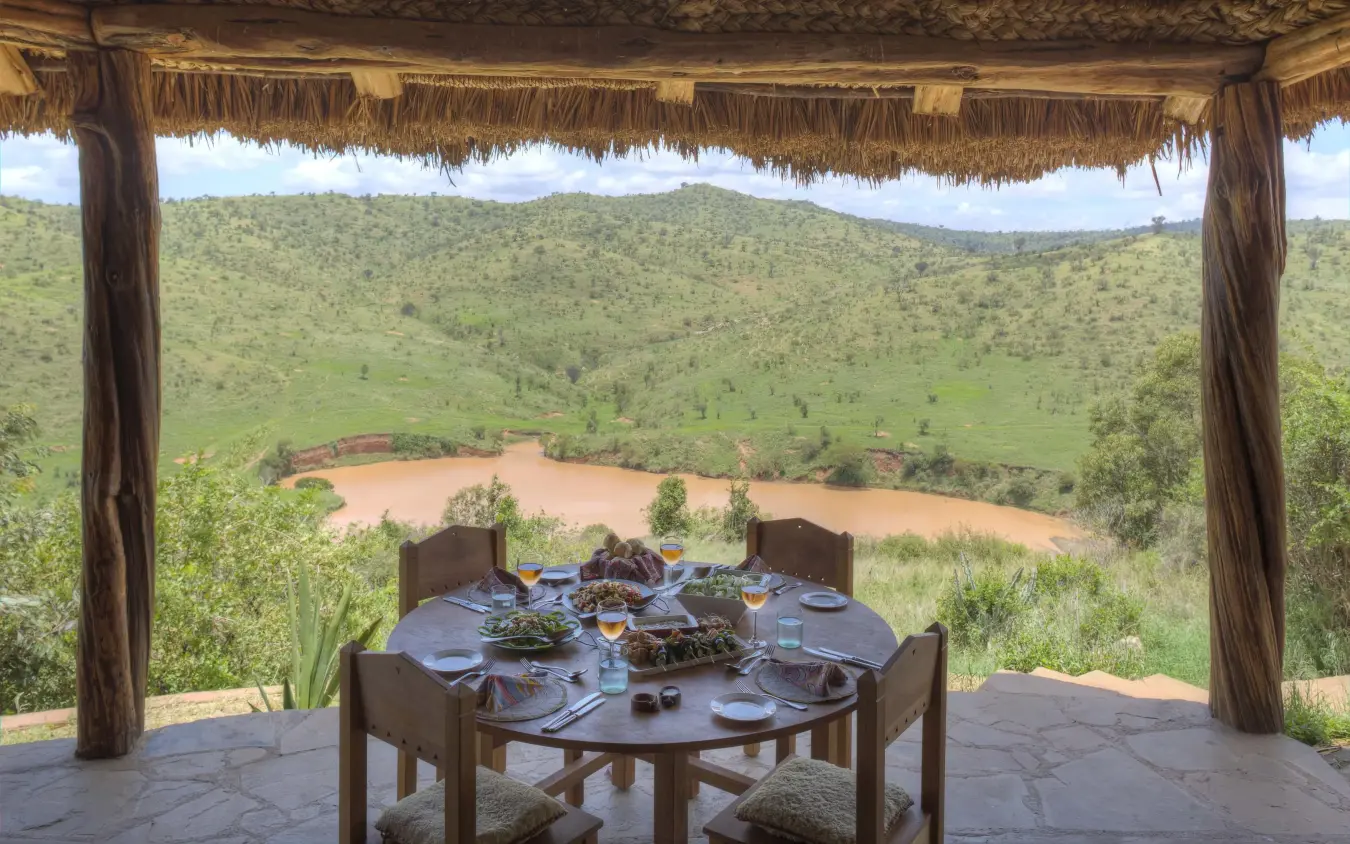 Dining table set on terrace overlooking river valley, Borana Lodge, Laikipia Highlands, Kenya