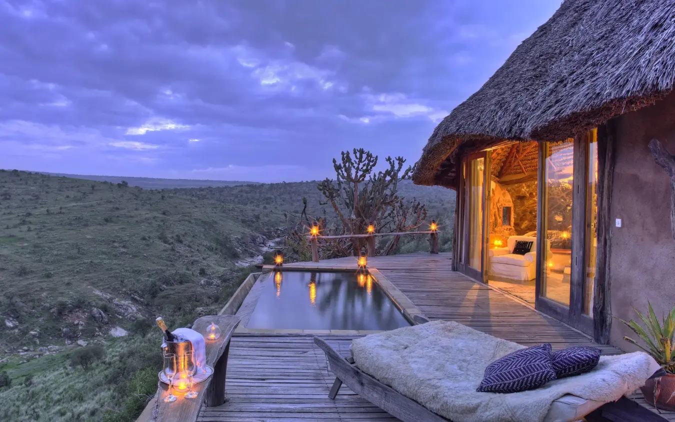 Wooden deck with infinity pool overlooking savanna at dusk, Borana Lodge, Laikipia Highlands, Kenya