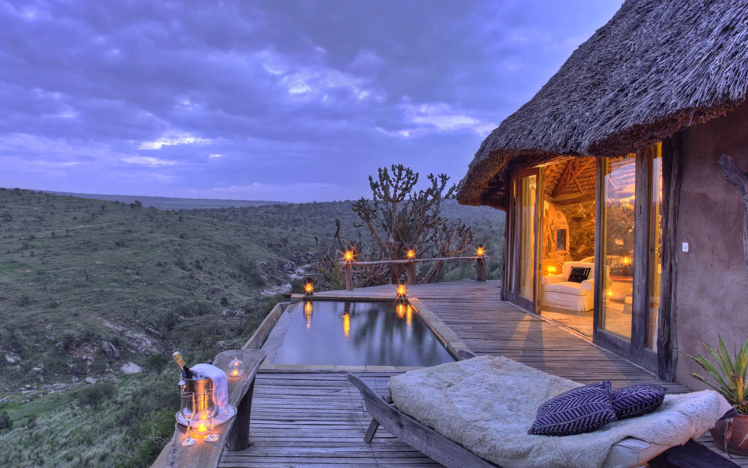 Wooden deck with infinity pool overlooking savanna at dusk, Borana Lodge, Laikipia Highlands, Kenya