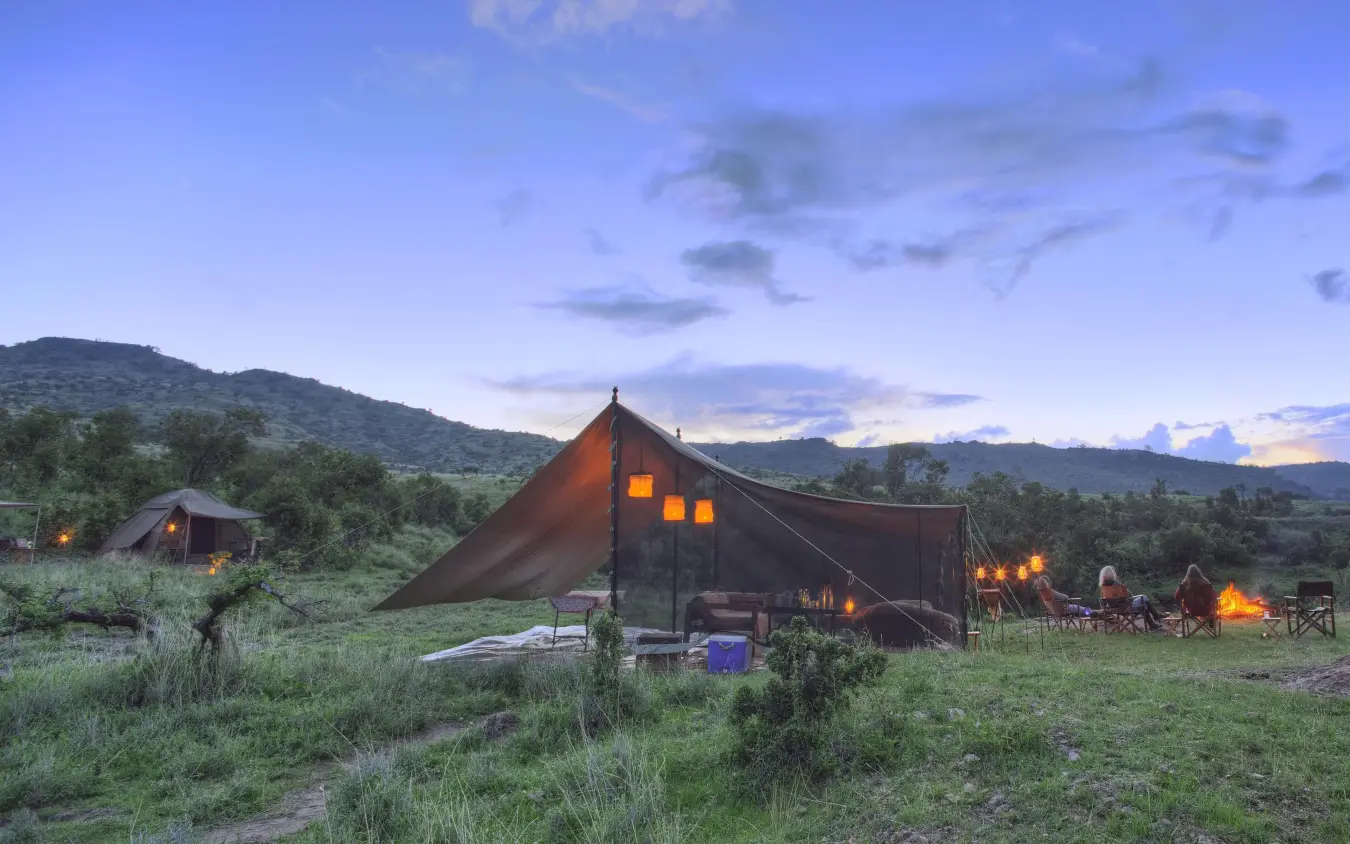 Canvas safari tents illuminated at dusk with mountains, Borana Lodge, Laikipia Highlands, Kenya