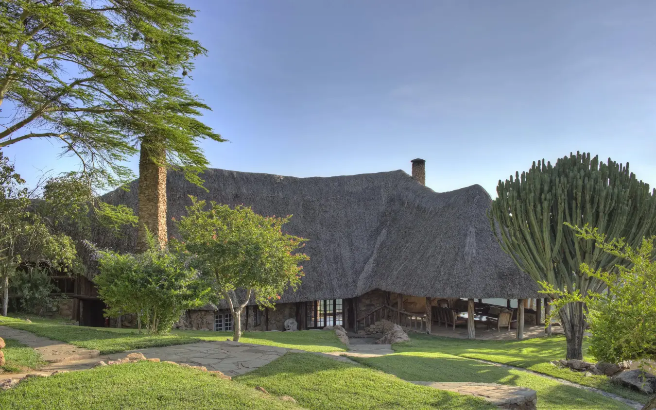 Thatched-roof lodge with manicured grounds and native plants, Borana Lodge, Laikipia Highlands, Kenya