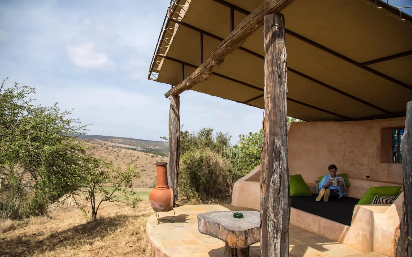 Rustic outdoor lounge area with canvas canopy and views, Borana Lodge, Laikipia Highlands, Kenya