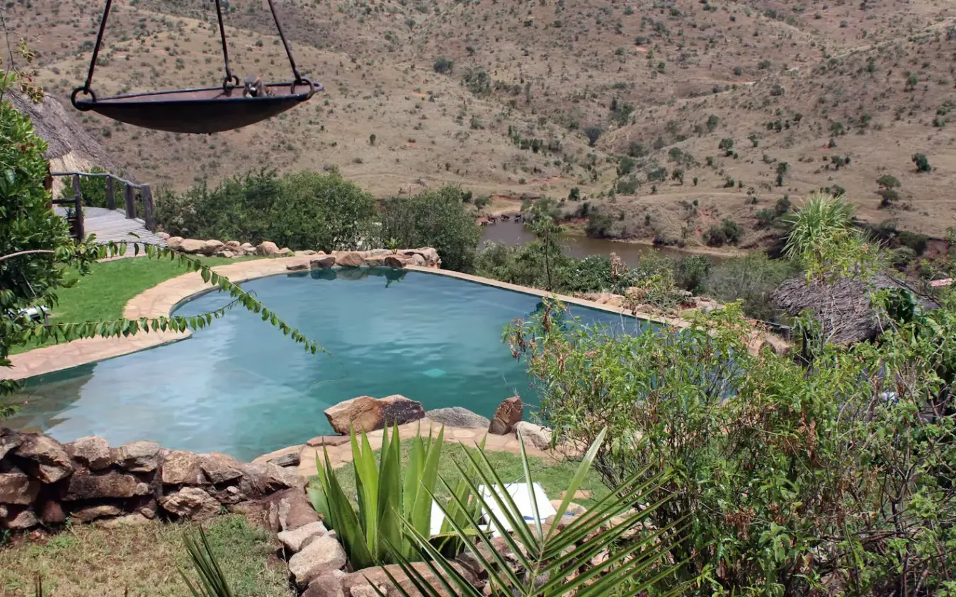 Resort pool overlooking valley with dry hillside landscape, Borana Lodge, Laikipia Highlands, Kenya