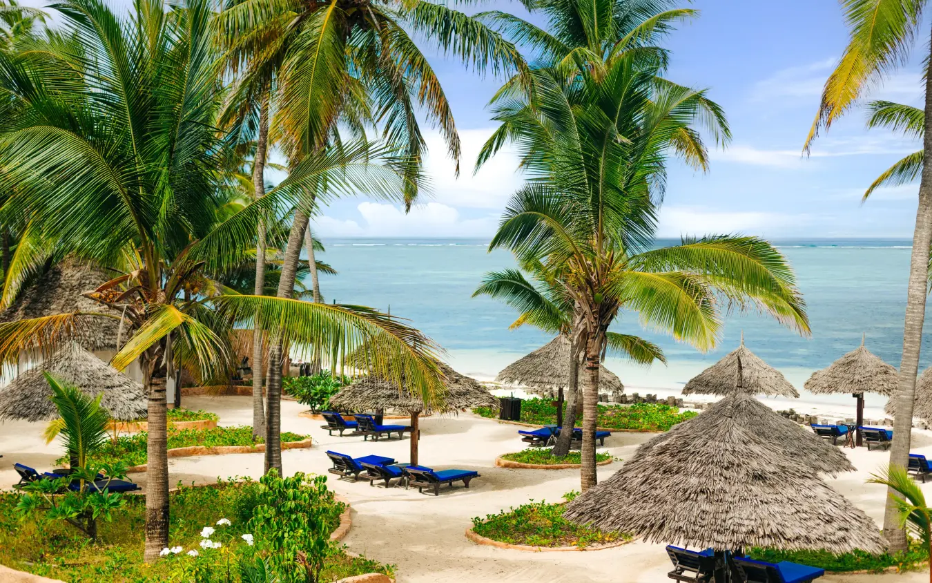 Beach resort with thatched umbrellas and palm trees overlooking turquoise ocean, Breezes Beach Club & Spa, Zanzibar & Pemba, Tanzania