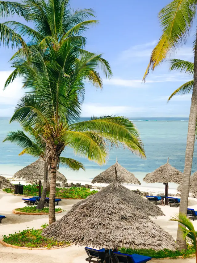 Beach resort with thatched umbrellas and palm trees overlooking turquoise ocean, Breezes Beach Club & Spa, Zanzibar & Pemba, Tanzania