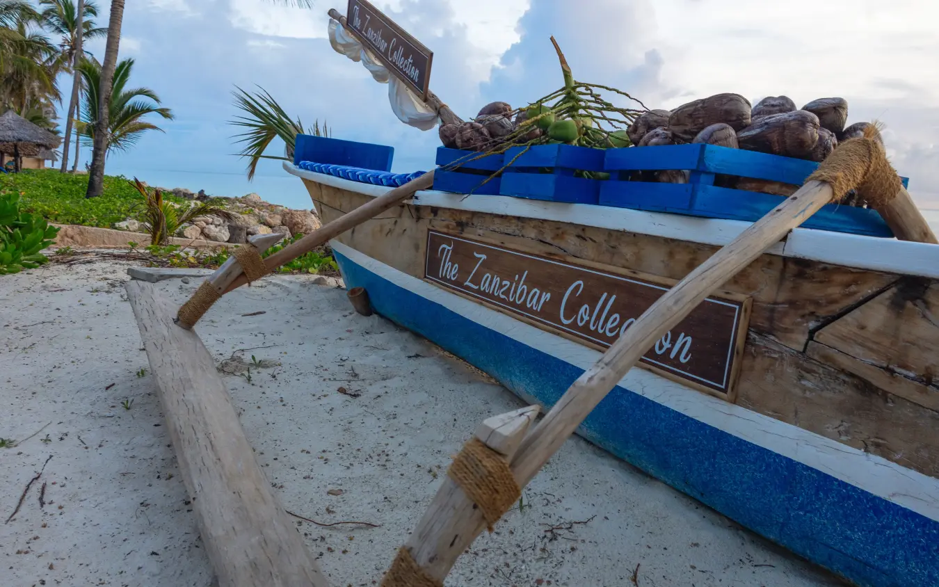 Traditional fishing boat beached on sandy shore with palm trees, Breezes Beach Club & Spa, Zanzibar & Pemba, Tanzania