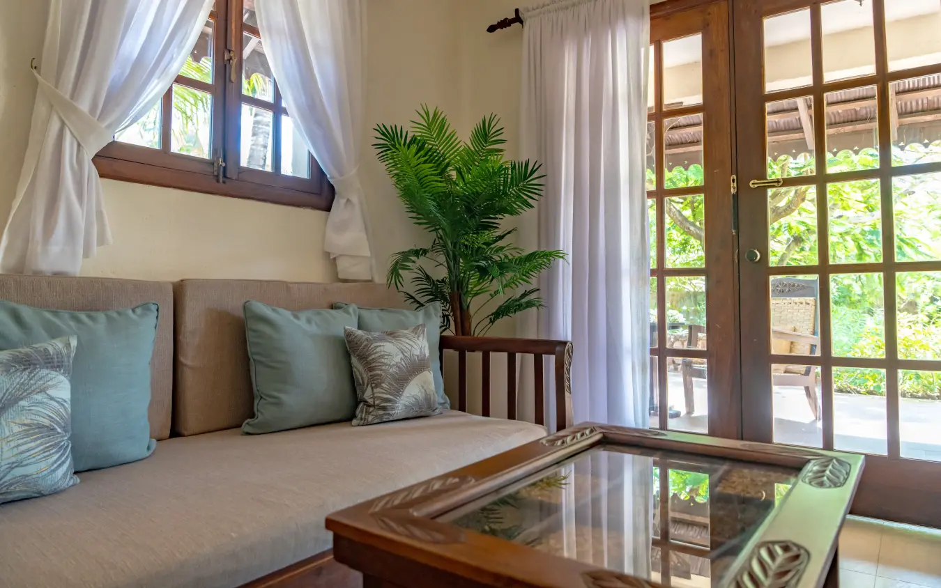 Luxury bedroom suite with glass doors opening to lush garden views, Breezes Beach Club & Spa, Zanzibar & Pemba, Tanzania