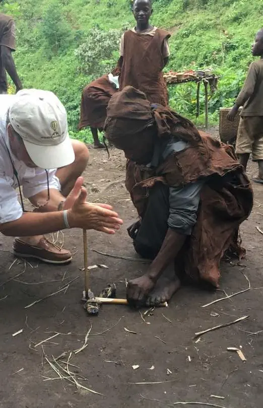 Guide demonstrating traditional fire-making technique to visitors, Buhoma Lodge, Bwindi Impenetrable Forest, Uganda