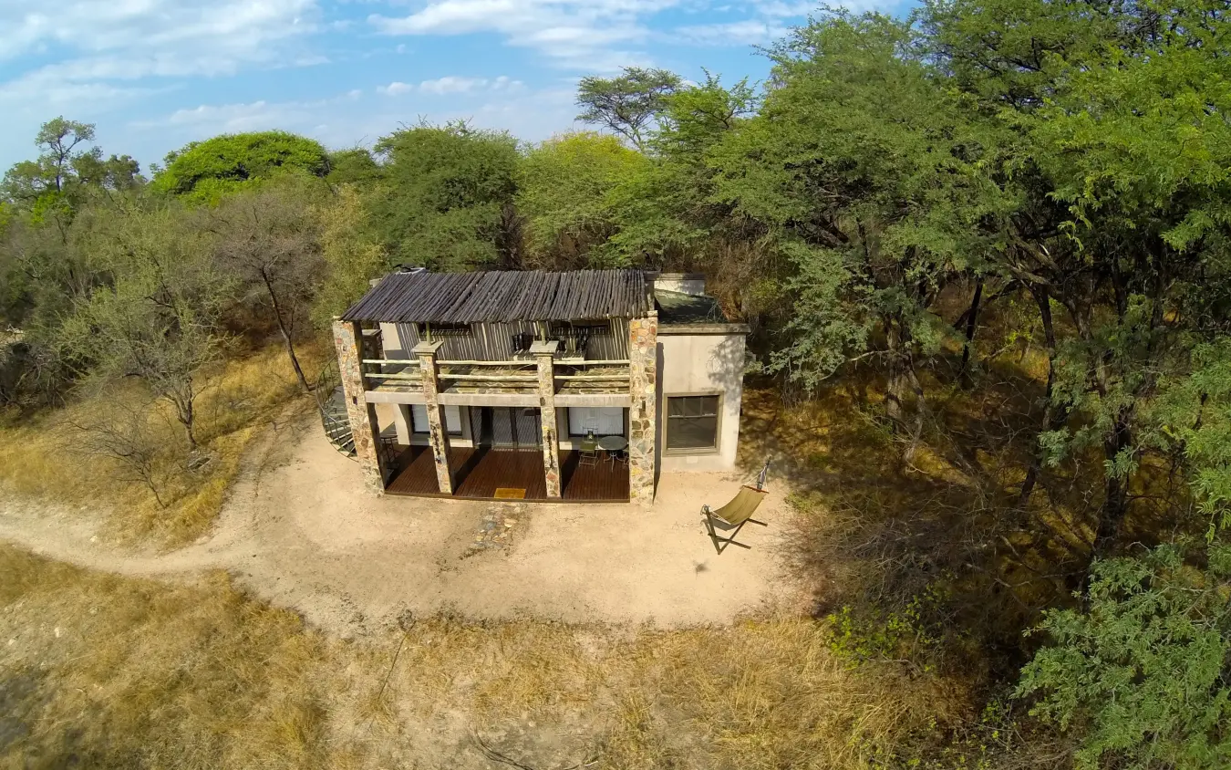 Elevated safari lodge surrounded by acacia trees in dry bushland, Camelthorn Lodge, Hwange National Park, Zimbabwe