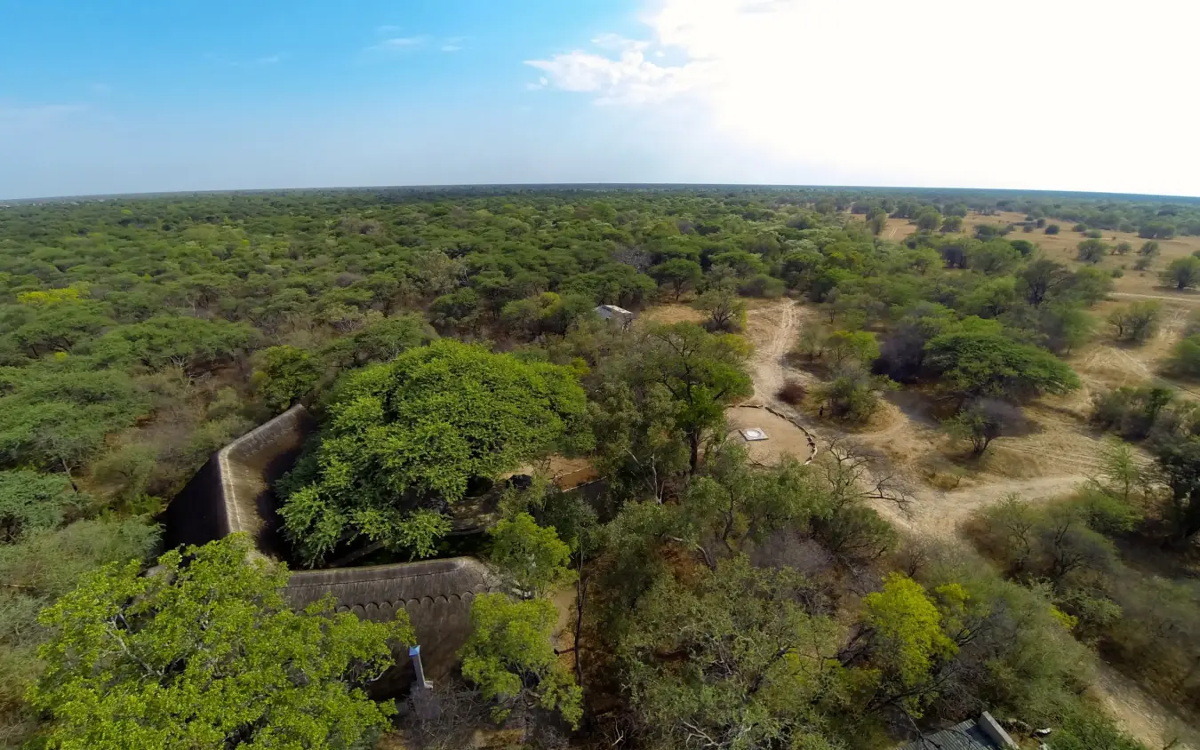 Aerial view of savanna landscape with stone structure and scattered trees, Camelthorn Lodge, Hwange National Park, Zimbabwe