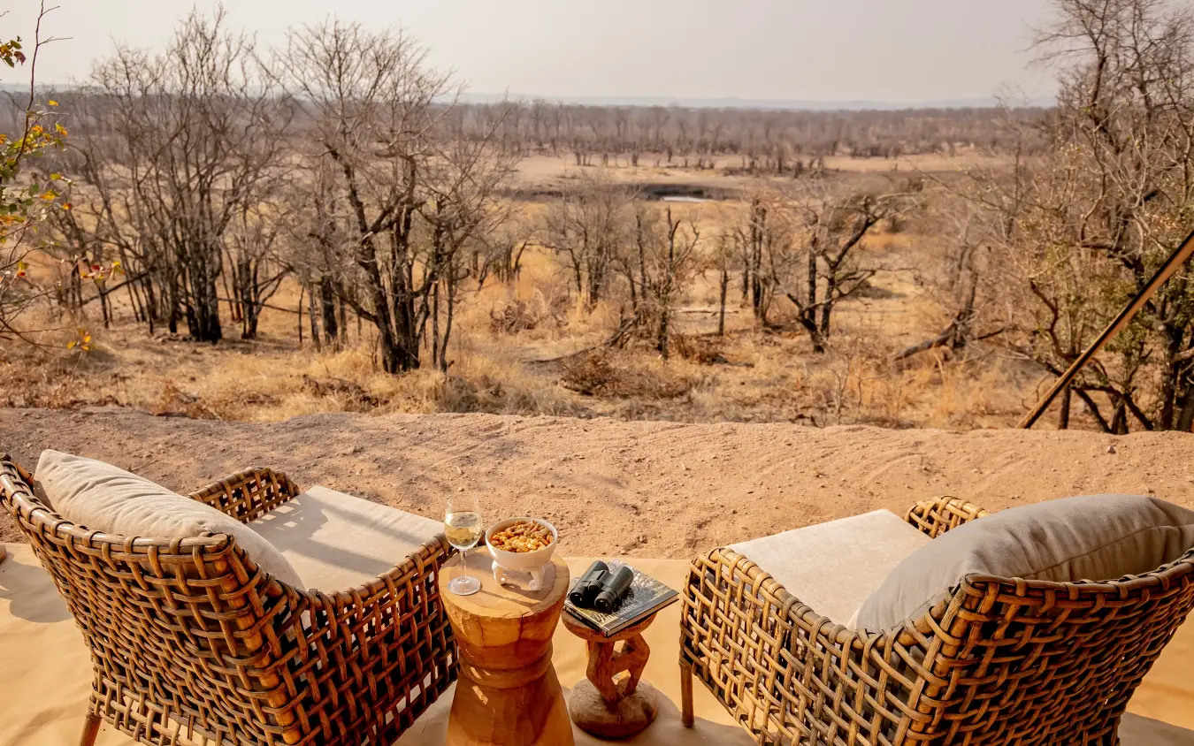 Woven chairs with refreshments overlooking arid savanna landscape, Camp Chitubu, Hwange National Park, Zimbabwe
