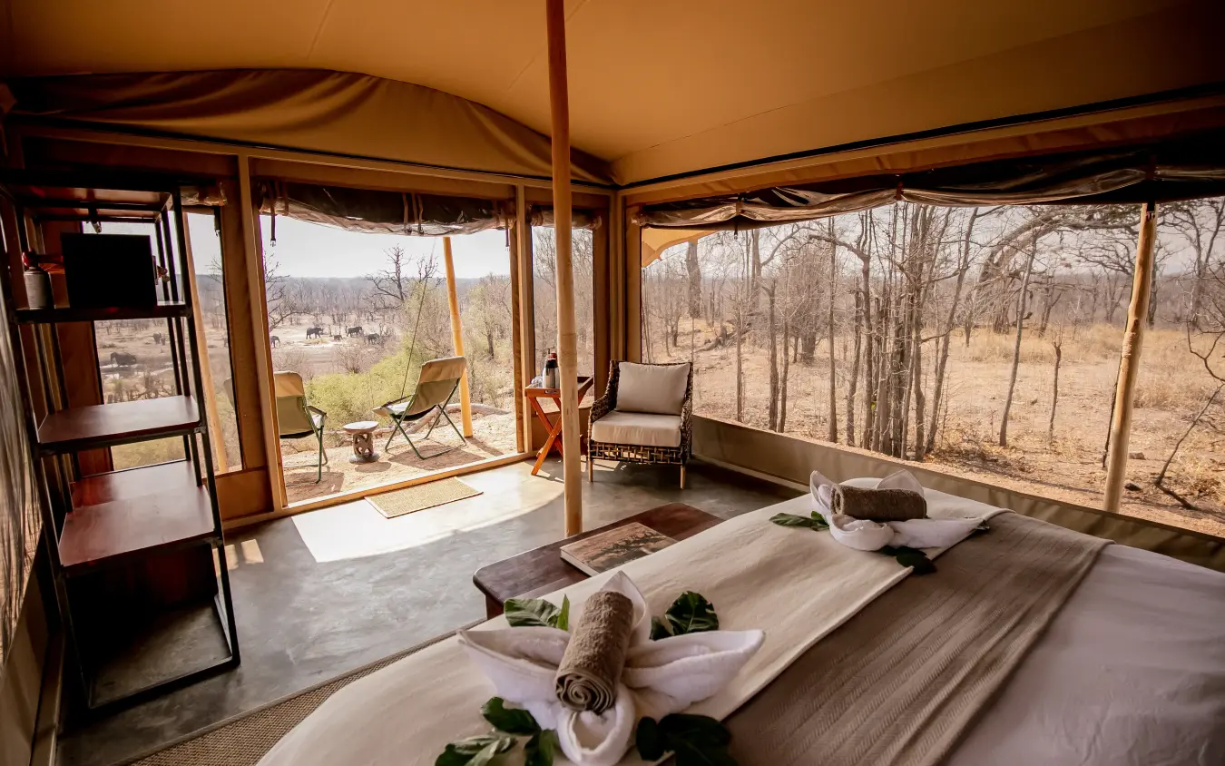 Luxury safari tent bedroom with panoramic views of woodland landscape, Camp Chitubu, Hwange National Park, Zimbabwe