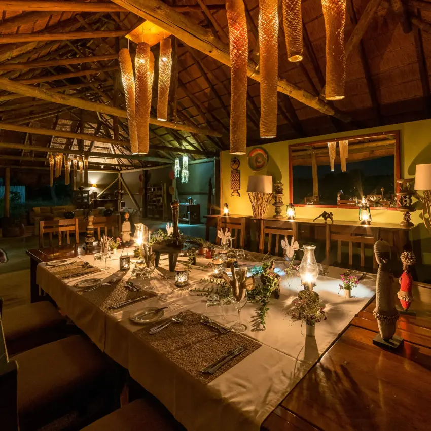 Dining room with long table set for evening service, Camp Hwange, Hwange National Park, Zimbabwe
