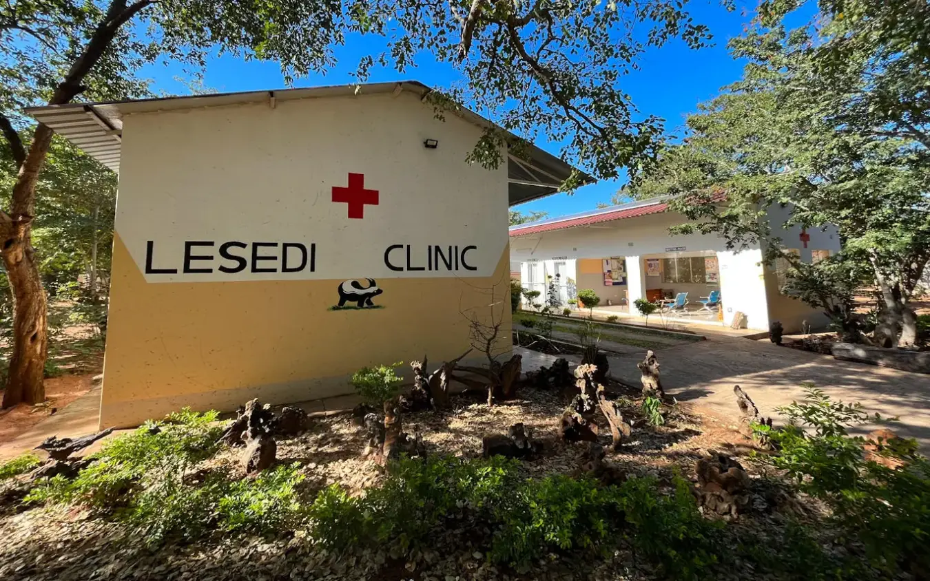 Clinic building with red cross sign and trees, Camp Hwange, Hwange National Park, Zimbabwe