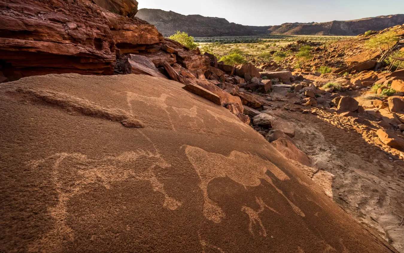 Ancient rock art etched into desert sandstone hillside, Camp Kipwe, Damaraland, Namibia