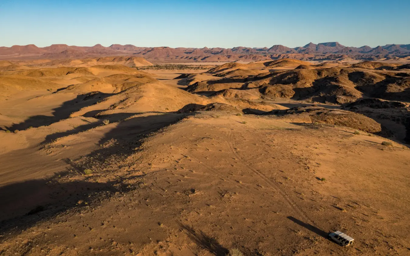 Vast desert landscape with volcanic formations and distant mountains, Camp Kipwe, Damaraland, Namibia
