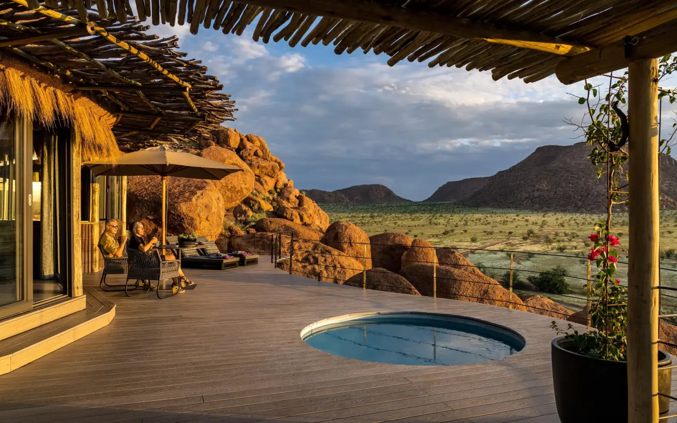 Wooden deck with pool overlooking savanna and rock formations, Camp Kipwe, Damaraland, Namibia