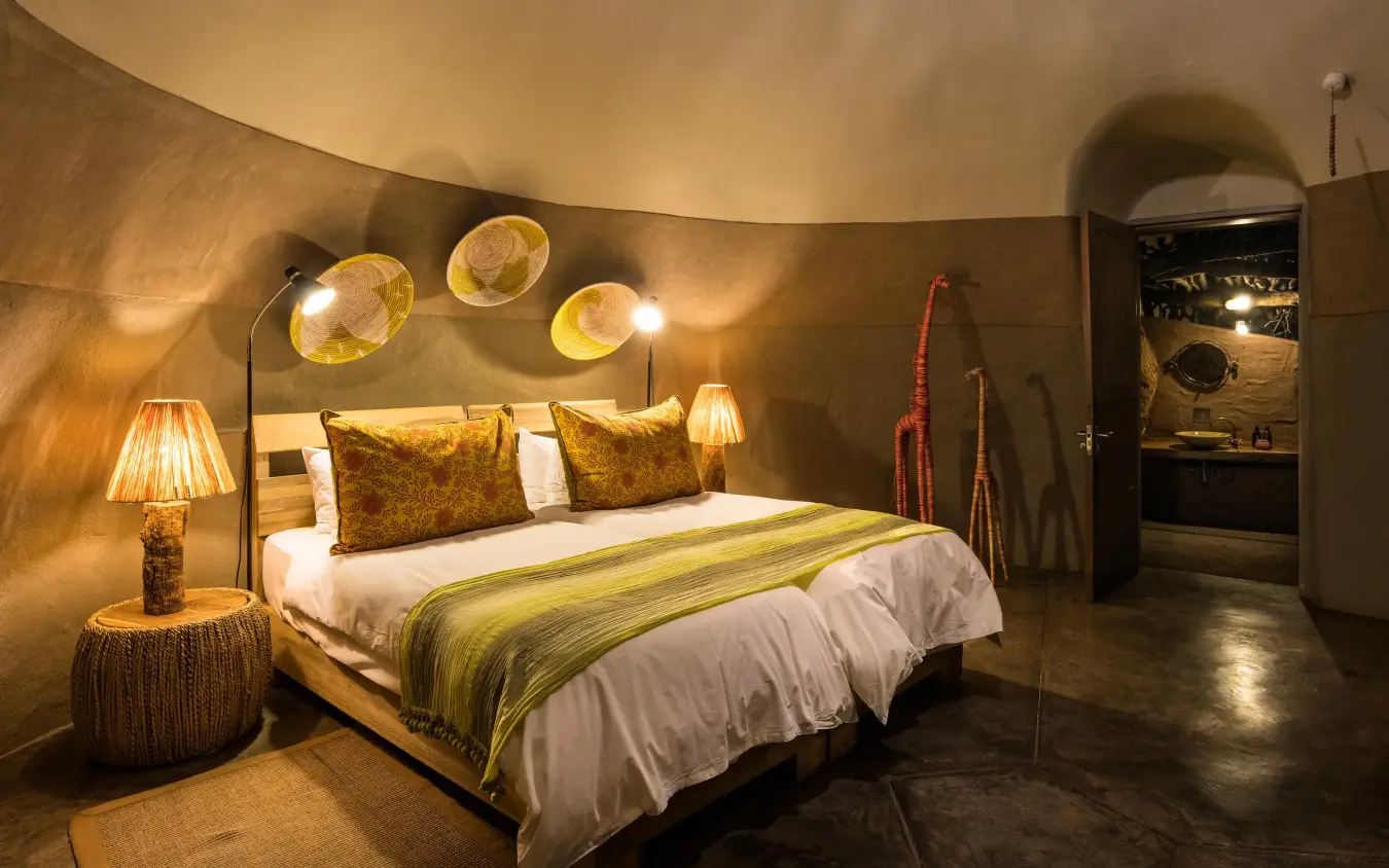 Luxury bedroom with curved walls and golden accents, Camp Kipwe, Damaraland, Namibia
