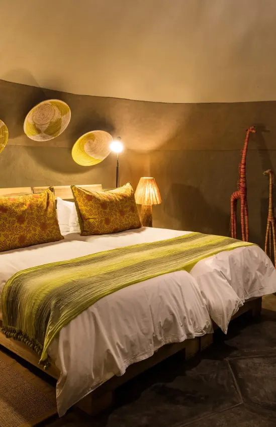 Luxury bedroom with curved walls and golden accents, Camp Kipwe, Damaraland, Namibia