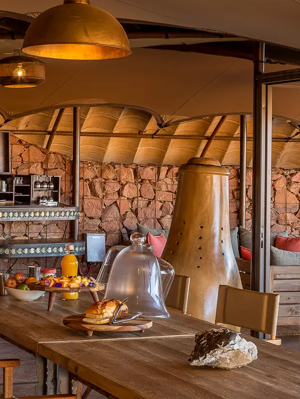 Modern dining area with stone walls and desert views, Camp Sossus, Sossusvlei, Namibia
