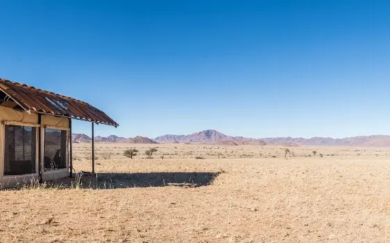 Barrel-decorated structure in vast desert landscape, Camp Sossus, Sossusvlei, Namibia