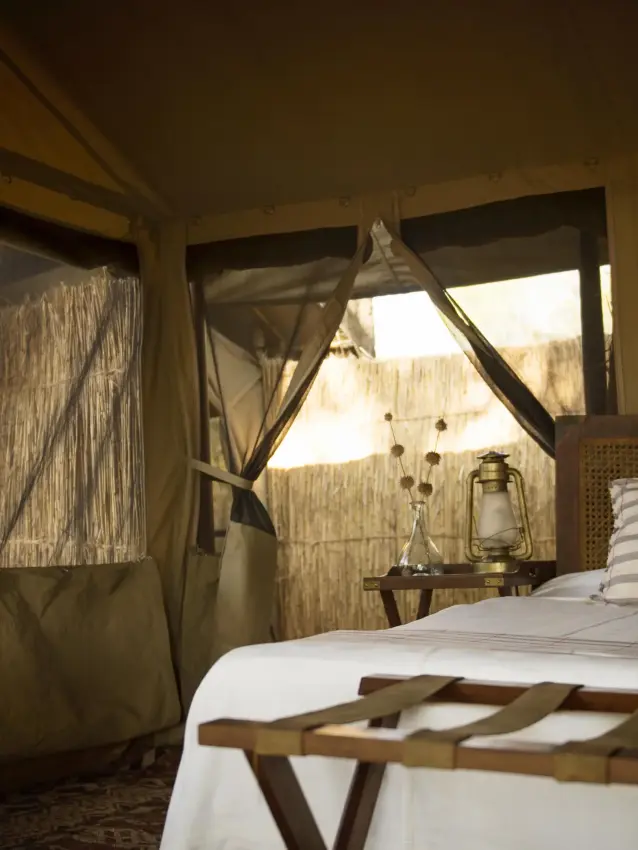 Safari bedroom interior with large windows and canvas walls, Chada Camp, Katavi National Park, Tanzania