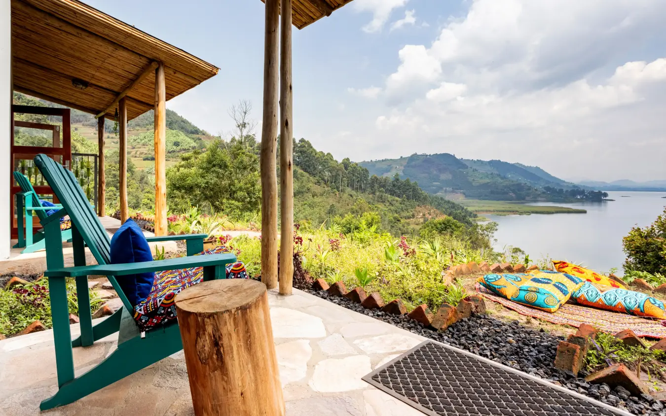 Wooden deck with green chair overlooking lake and mountains, Chameleon Hill Lodge, Lake Mutanda, Uganda