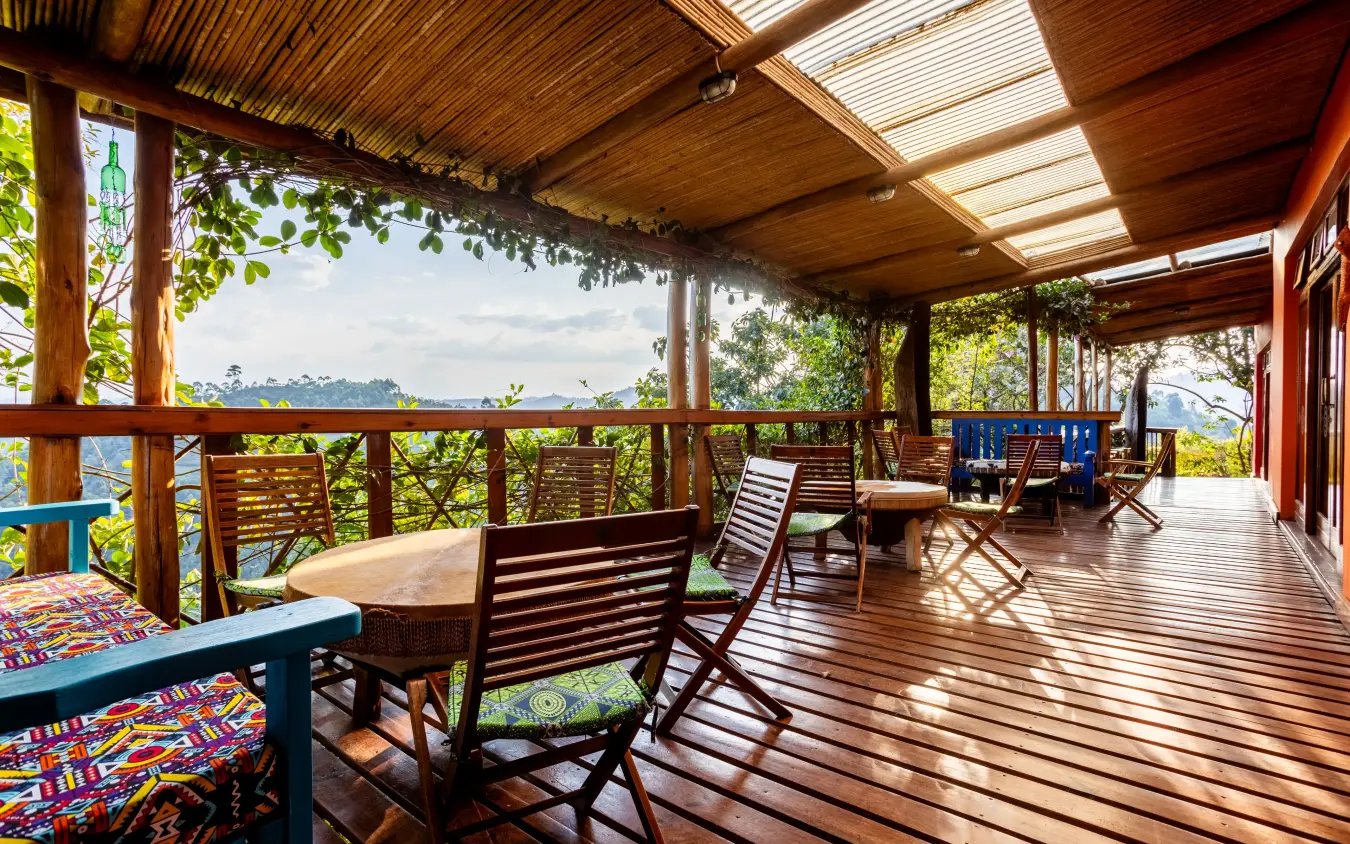 Wooden deck with seating overlooking forested landscape and lake, Chameleon Hill Lodge, Lake Mutanda, Uganda
