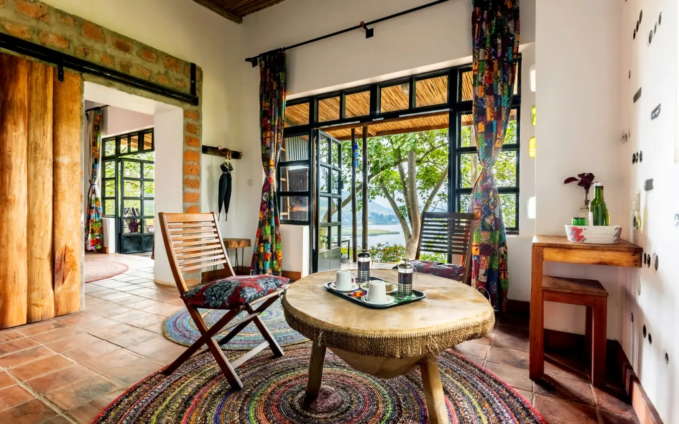 Open-plan interior lounge with lake views through large windows, Chameleon Hill Lodge, Lake Mutanda, Uganda
