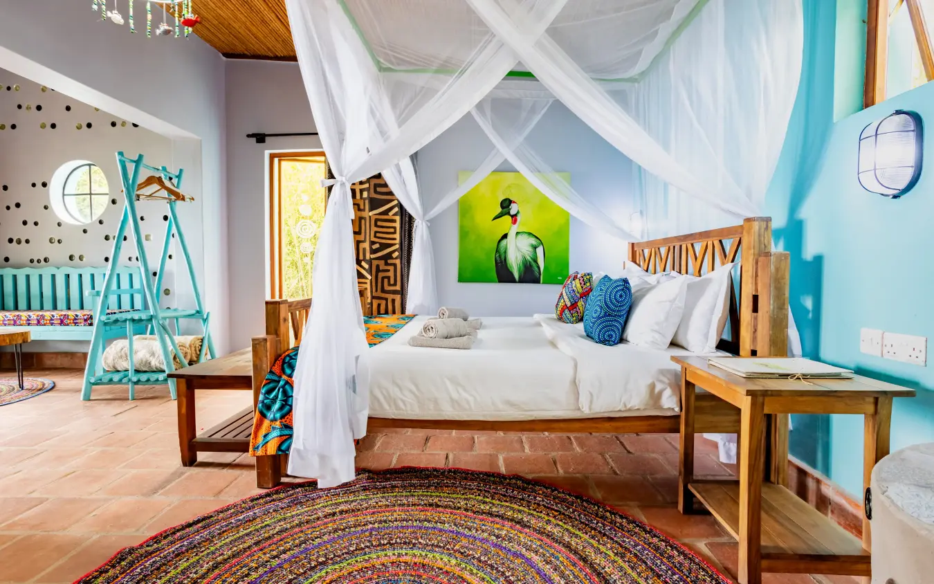 Bedroom with canopy bed, colorful décor, and artwork, Chameleon Hill Lodge, Lake Mutanda, Uganda