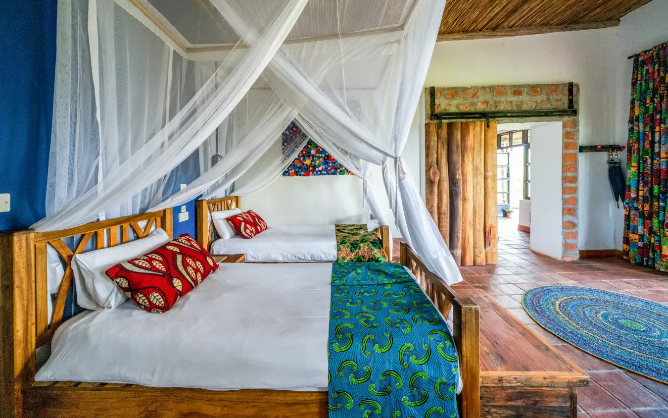 Spacious bedroom with four-poster bed and white canopy drapes, Chameleon Hill Lodge, Lake Mutanda, Uganda
