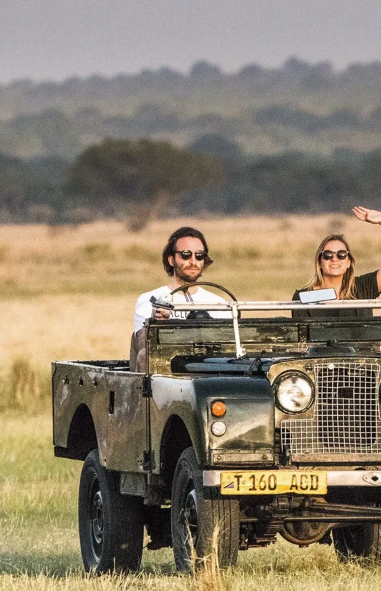 Guests in vintage Land Rover vehicle on safari game drive, Chem Chem Lodge, Lake Manyara, Tanzania