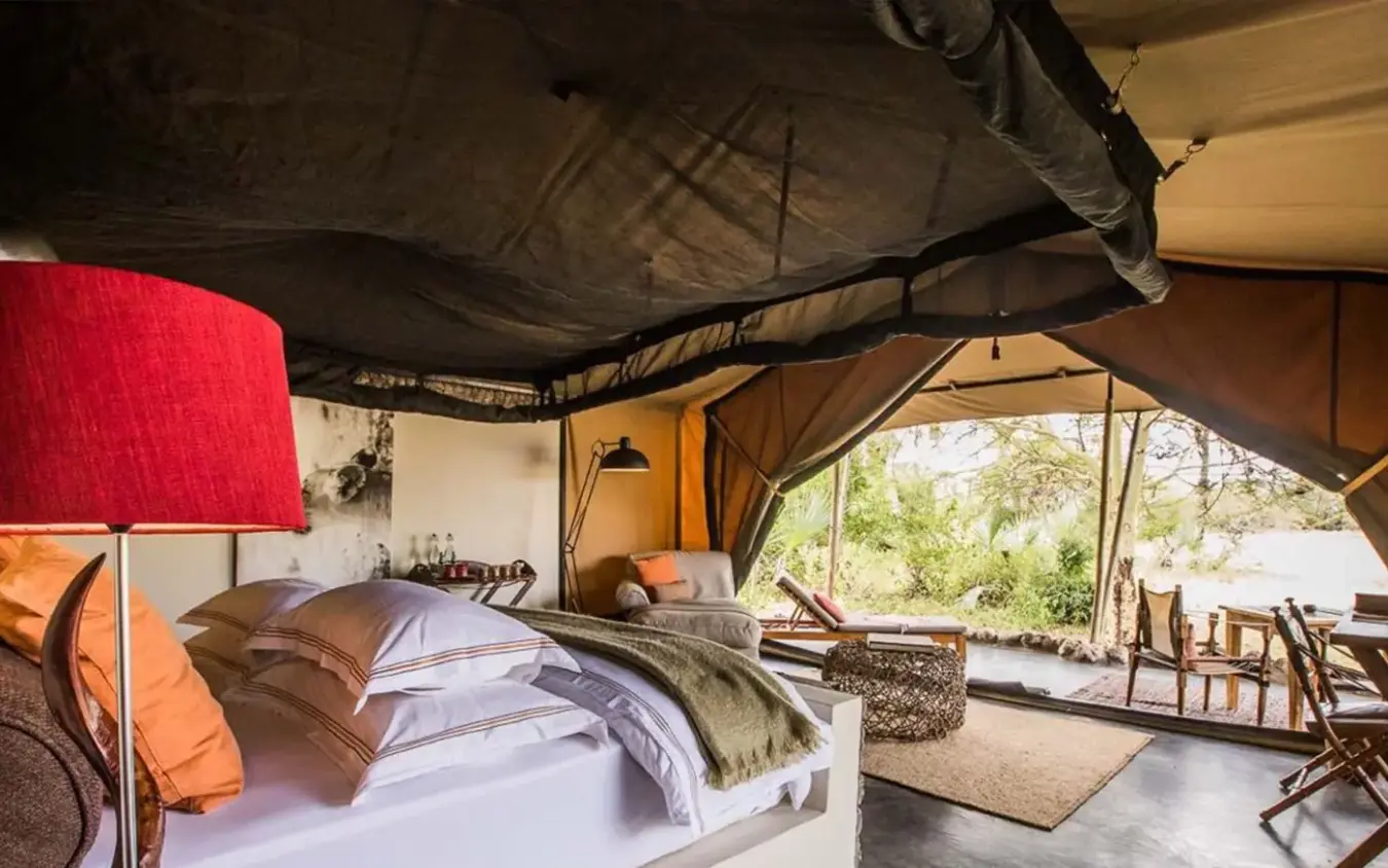Safari tent bedroom with view of outdoor seating area, Chem Chem Lodge, Lake Manyara, Tanzania