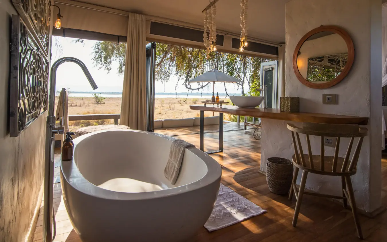 Freestanding bathtub with view of savanna and waterhole, Chikwenya Camp, Mana Pools, Zimbabwe