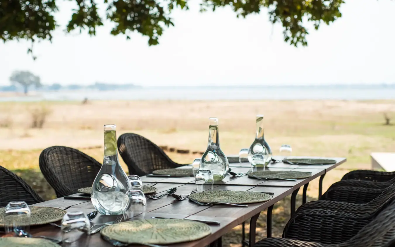 Outdoor dining setup overlooking African savanna landscape, Chikwenya Camp, Mana Pools, Zimbabwe