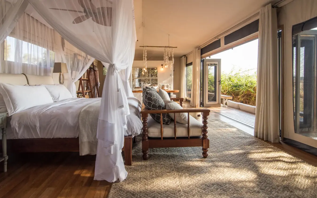 Luxurious bedroom with four-poster bed and deck views, Chikwenya Camp, Mana Pools, Zimbabwe