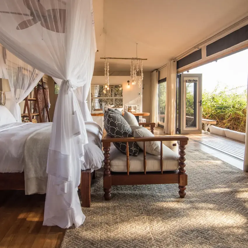 Luxurious bedroom with four-poster bed and deck views, Chikwenya Camp, Mana Pools, Zimbabwe