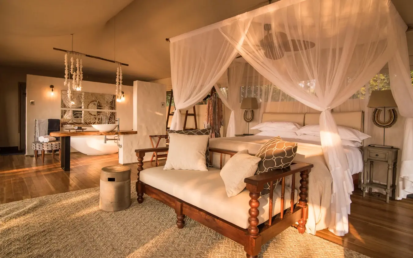 Spacious bedroom with four-poster bed and sheer canopy drapes, Chikwenya Camp, Mana Pools, Zimbabwe