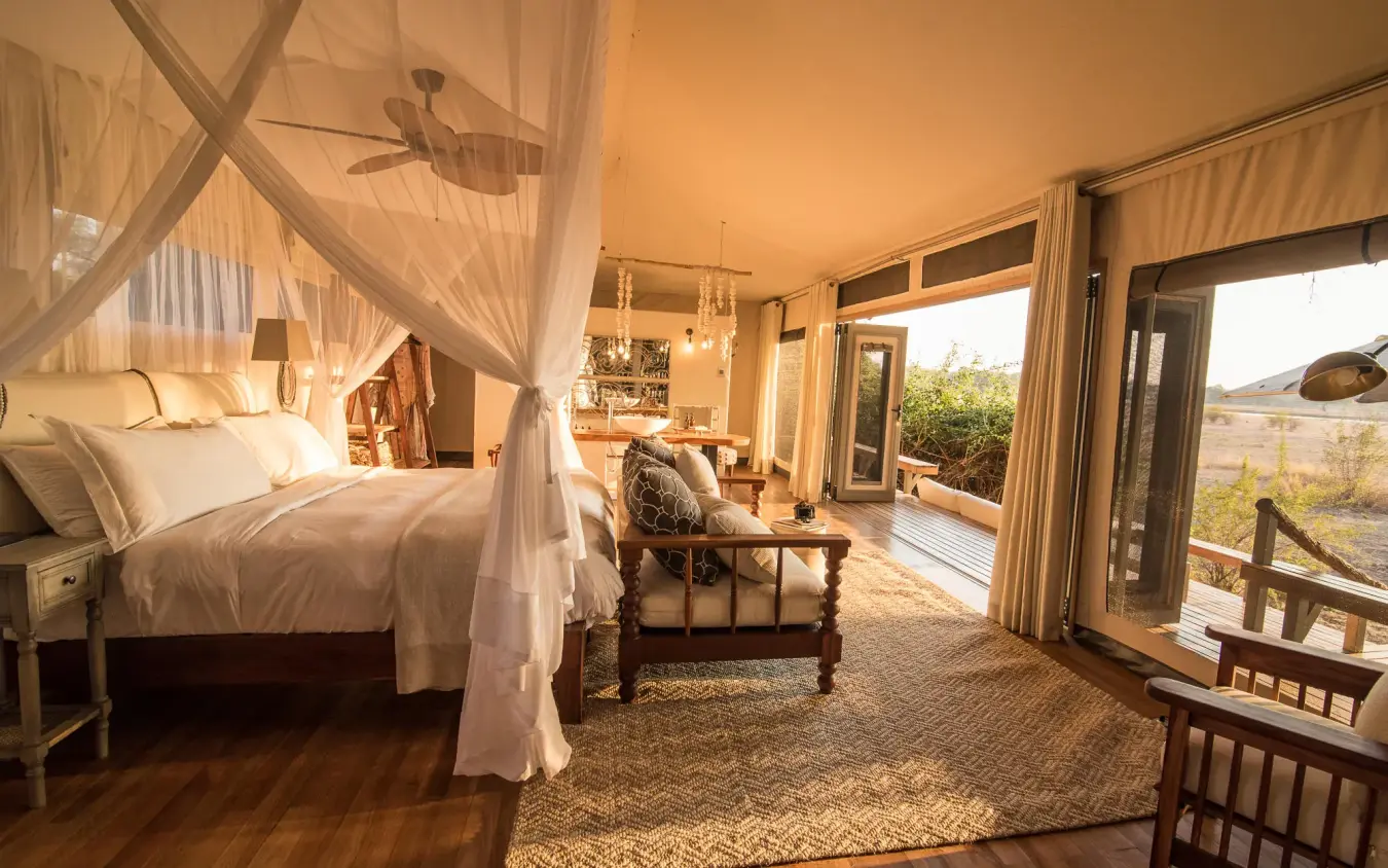 Luxury bedroom suite with four-poster canopy bed and open views, Chikwenya Camp, Mana Pools, Zimbabwe