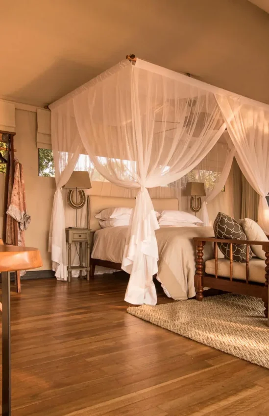 Spacious safari bedroom with canopy bed and open-air design, Chikwenya Camp, Mana Pools, Zimbabwe
