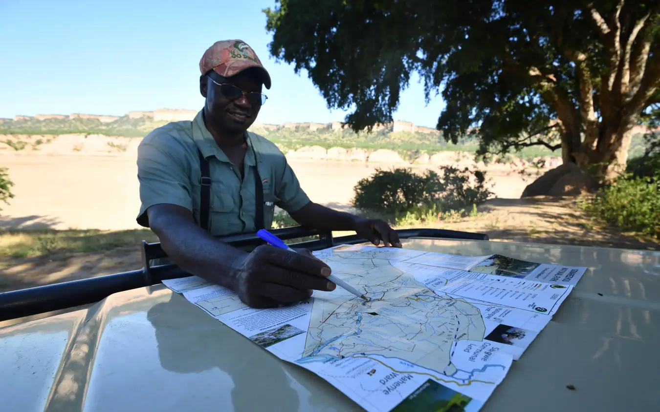 Guide reviewing maps and plans on vehicle hood, Chilo Gorge Safari Lodge, Gonarezhou & Malilangwe, Zimbabwe