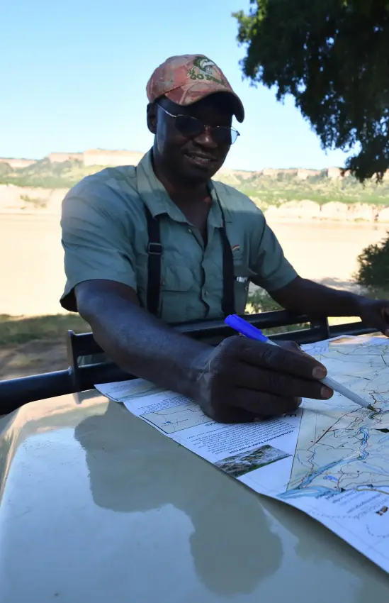 Guide reviewing maps and plans on vehicle hood, Chilo Gorge Safari Lodge, Gonarezhou & Malilangwe, Zimbabwe